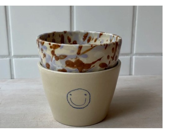Gesprenkelte und lächelnde Becher
